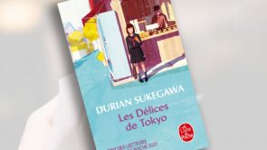 Hand holding a Japanese red bean pancake, dorayaki.