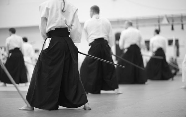 People in kimono and hakama standing and practicing sword technique